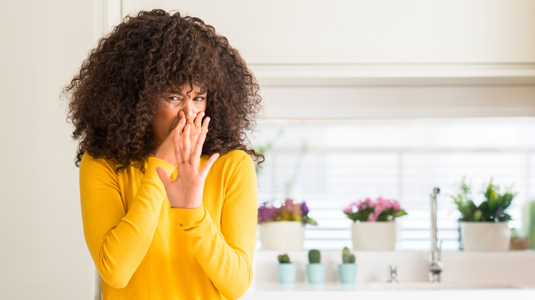 woman holding nose