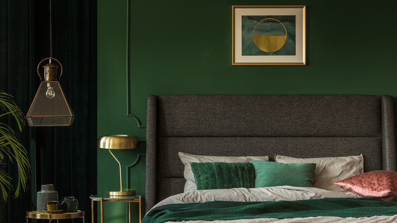 Emerald green walls with a gray bed and jewel-toned pillows