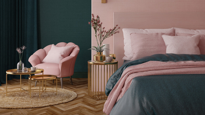Pale rose pink walls in front of a pink bed that is accented with deep green
