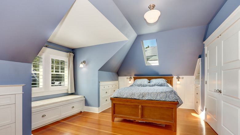 Periwinkle blue walls in an upstairs bedroom with brown floorboards