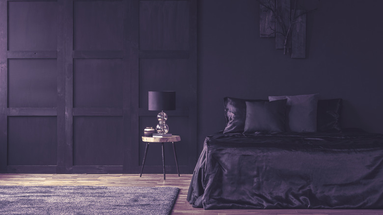 Deep purple bedroom with light brown floorboards
