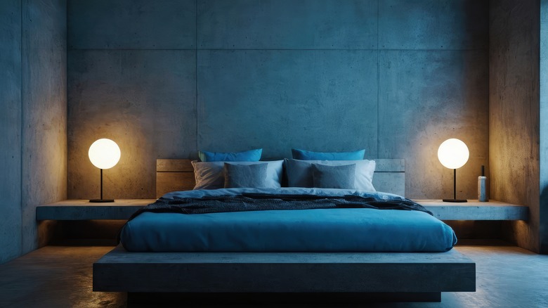 A teal blue bedroom with a double bed and two lamps