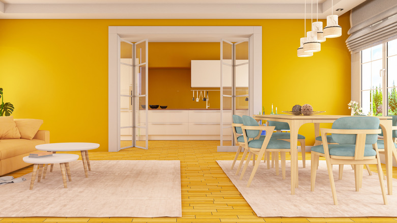 Yellow floors in a dining room with yellow walls, white trim, beige dinette, and blue cushions