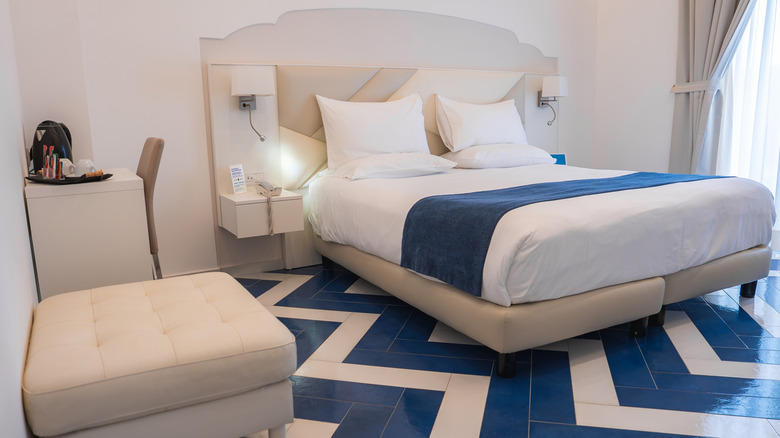 A bedroom with a blue and white chevron painted floor, and matching blue and white furnishings