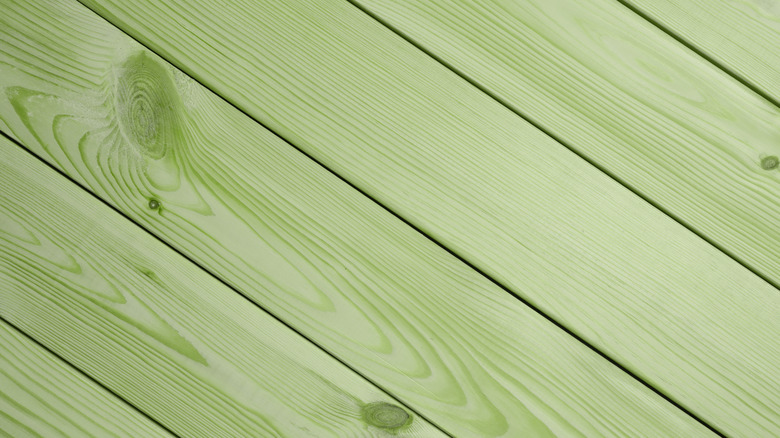 Close up of a whitewashed sage green wooden floor with the timber grain showing through