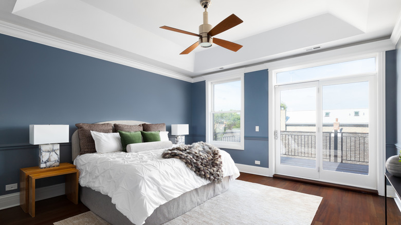Blue bedroom with a ceiling fan.