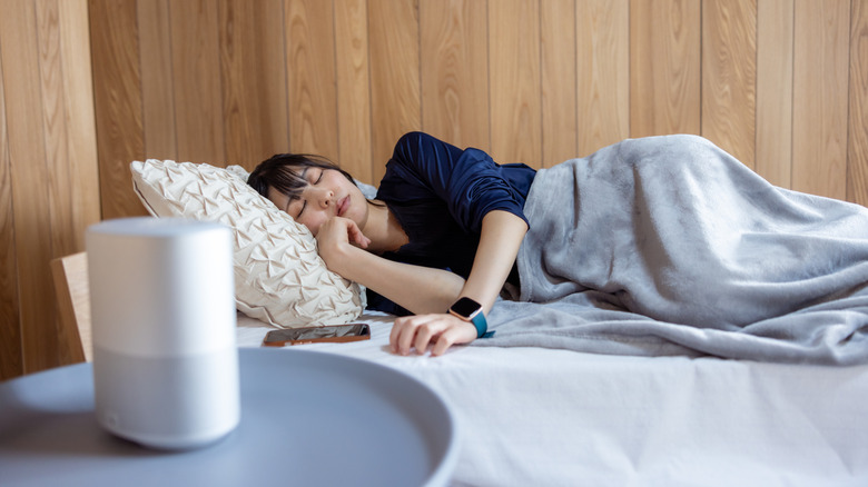 Woman sleeping in a bedroom, a phone next to her