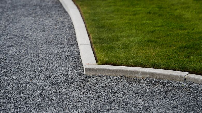 Gravel area with a concrete border separating it from grass