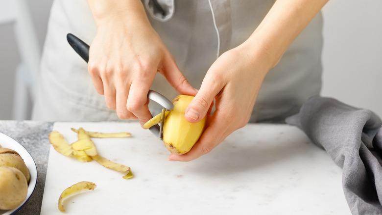 Person peeling potato