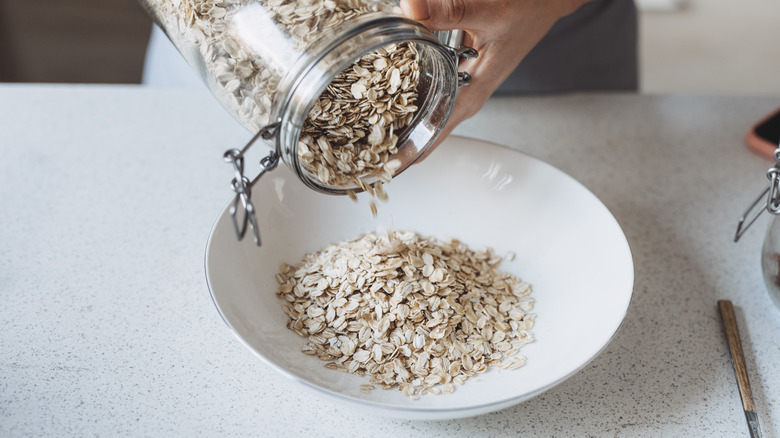 Person pouring oatmeal in bowl