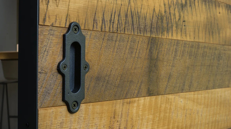 A flush cup pull is installed on a distressed door