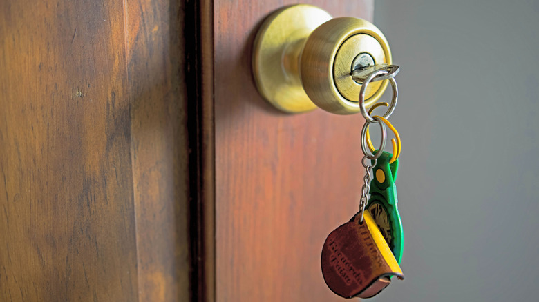 A set of keys hangs in a brass door knob