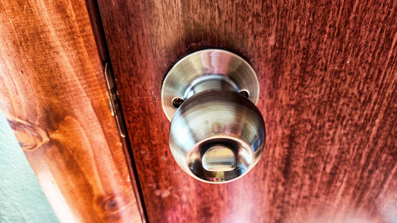 A metallic privacy door knob with tab lock turning mechanism