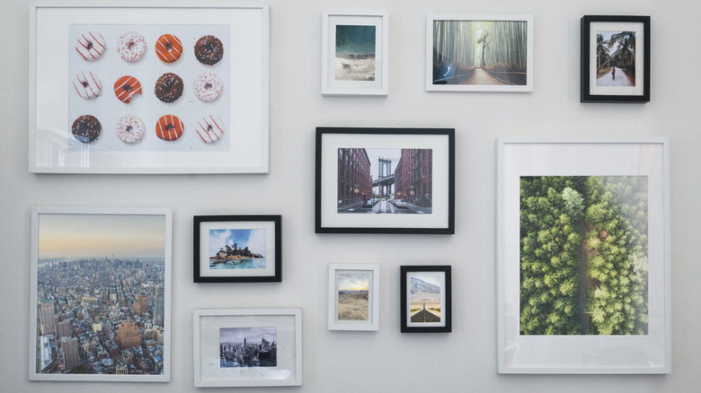 A wall filled with all sorts of pictures and arts in different sizes