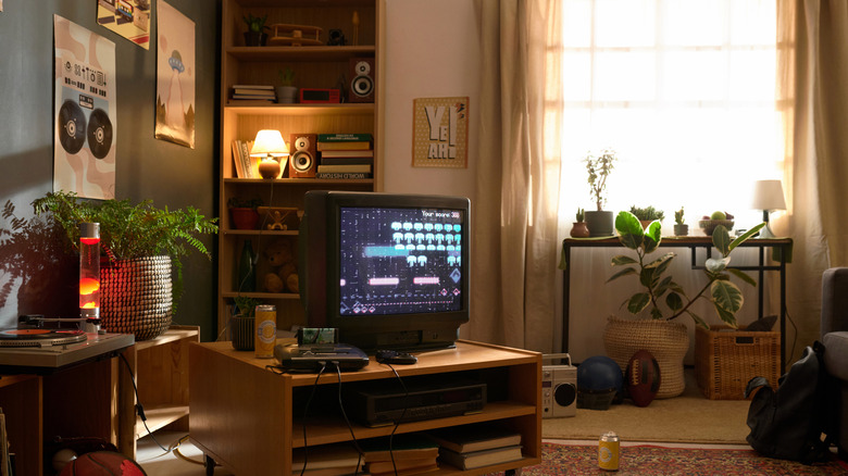A room with classic designs and items such as lava lamps, an old-school TV, and game consoles