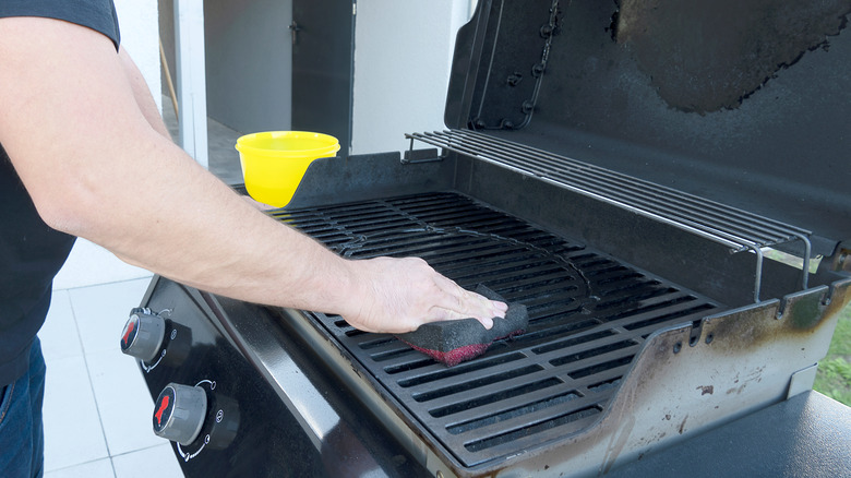 Man cleaning BBQ grill