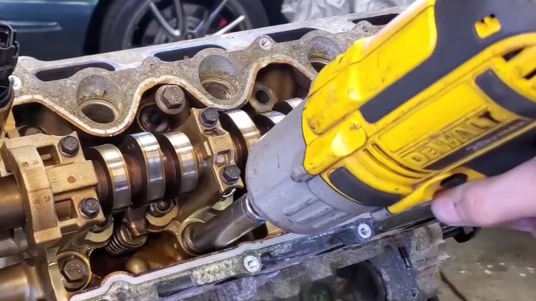 Person removing bolts from an engine with a DeWalt tool