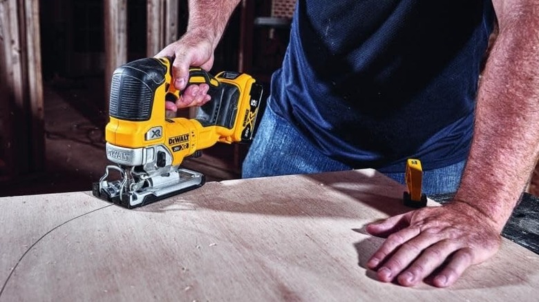 Man using a DeWalt jigsaw to cut wood