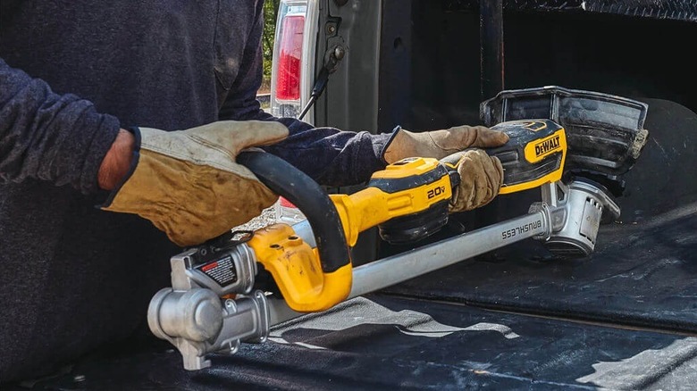Person loading a DeWalt folding string trimmer