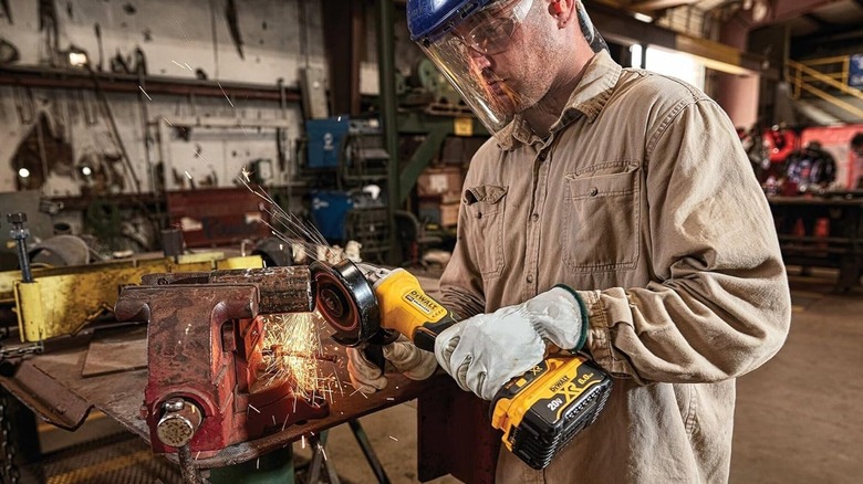 Person using a DeWalt grinder in a workshop