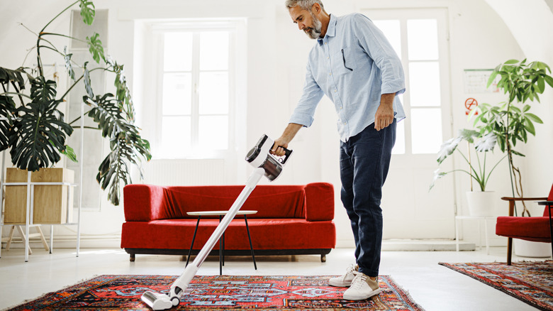 man cleaning living room