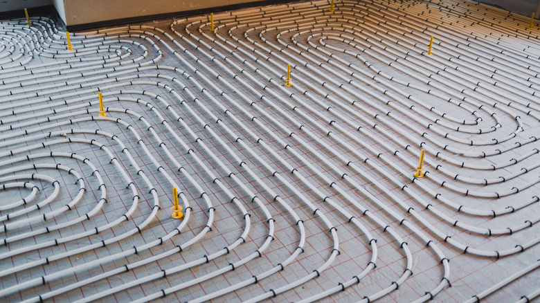 Installing heated flooring using plastic tubes