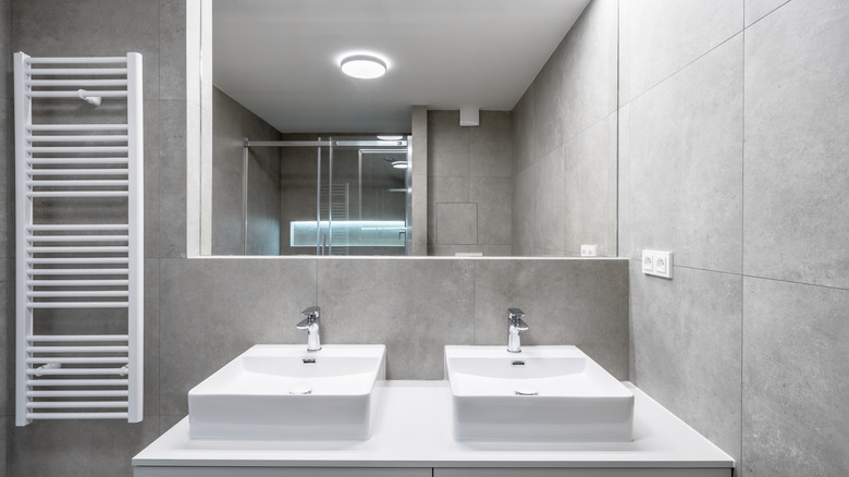 Large gray tiles in bathroom with double sinks