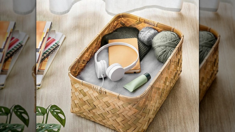 MJÖLKKANNA Basket holding headphones, hand cream, yarn, a notebook, a blanket, and a beanie