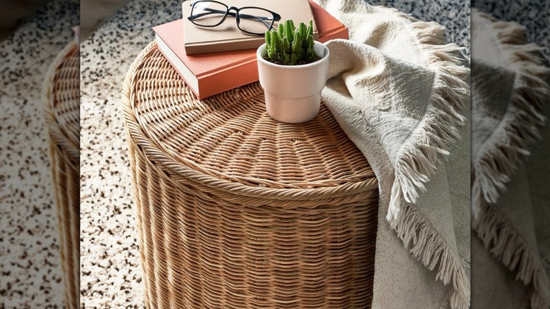 TOLKNING Ottoman being used as a side table with a plant and glasses on top