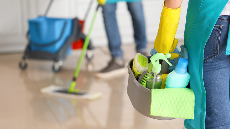 Couple with cleaning supplies