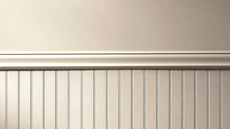 A wall with wainscoting painted a creamy beige color