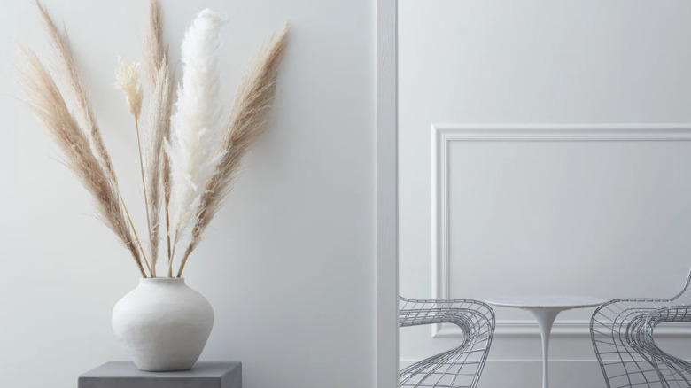A room painted a subtle gray-blue color with modern chairs and a vase