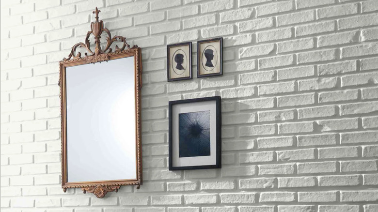 A brick wall with art painted a subtle gray color