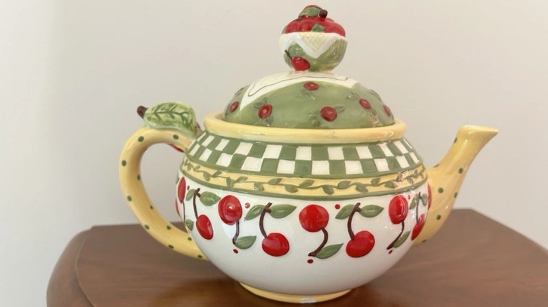 Mary Engelbreit teapot with a cherry motif.