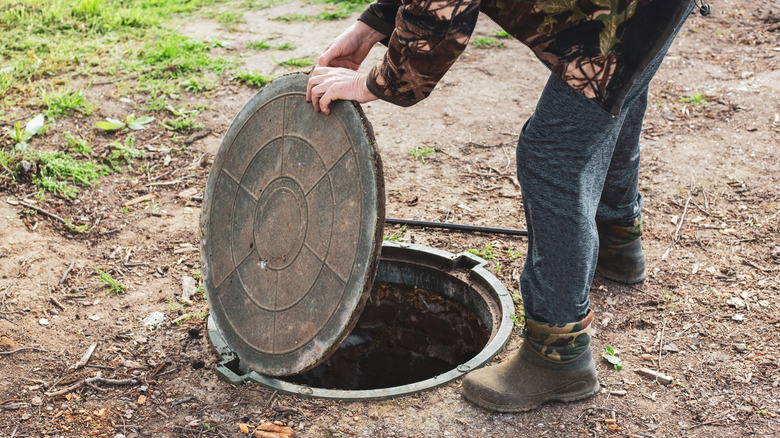 Man opening septic tank cover