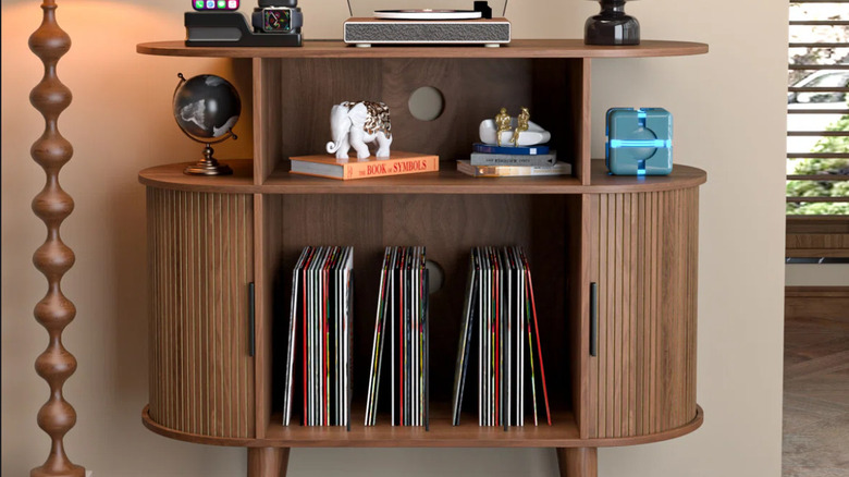 The rounded record stand with vinyl records, books, and accents.