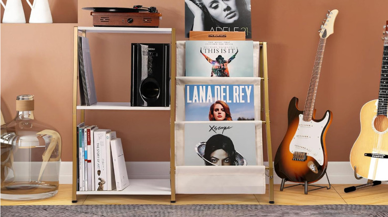 The gold and white tiered vinyl record stand with audio accessories.