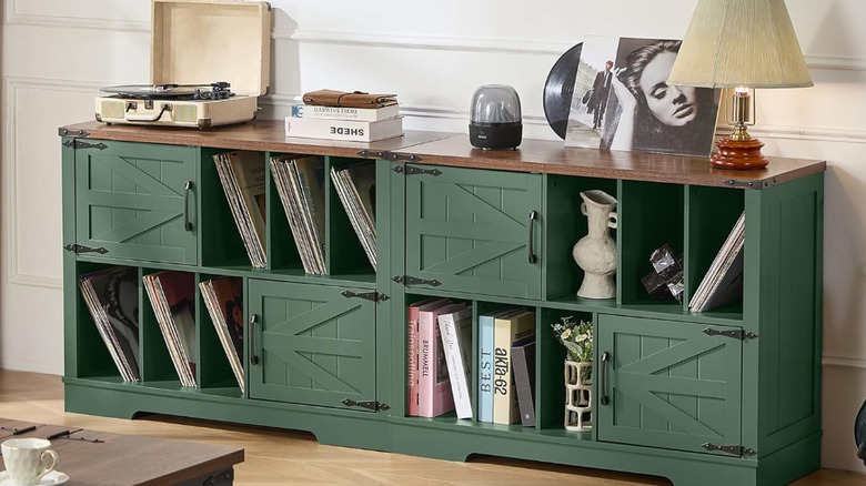 A green farmhouse style record cabinet with a turntable and books on top.