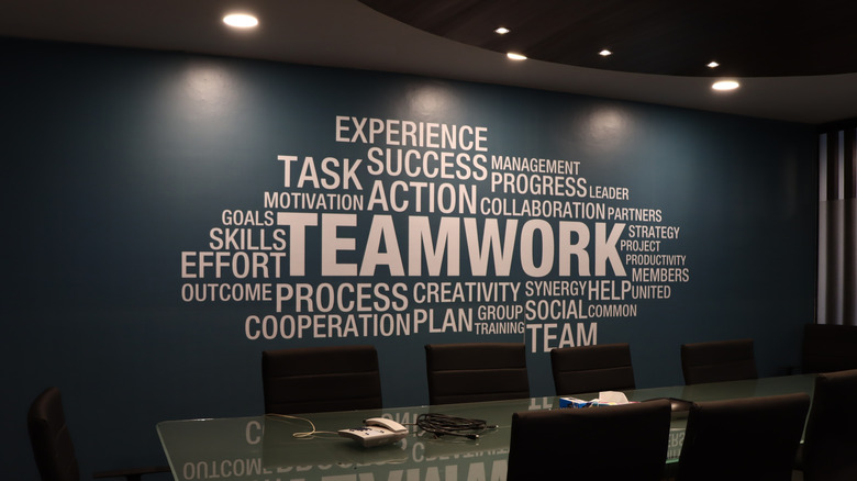dark office space with wordy motivational art written on the wall