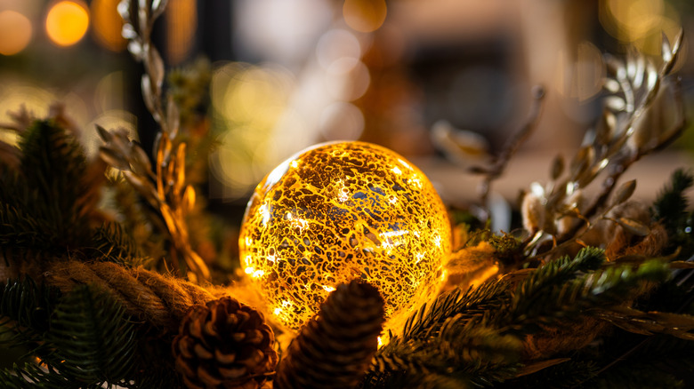 Pine boughs with a lighted Christmas bulbs on top