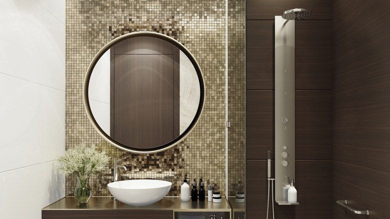 A small bathroom with bold decor in shades of deep brown and gold