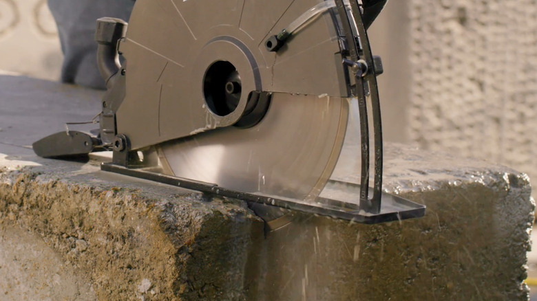 a concrete saw cuts through a few inches of concrete