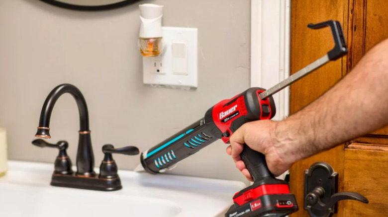 person using the Bauer caulk gun around a bathroom sink