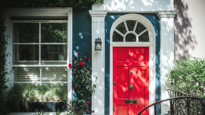 A blue home with a red front door and white trim