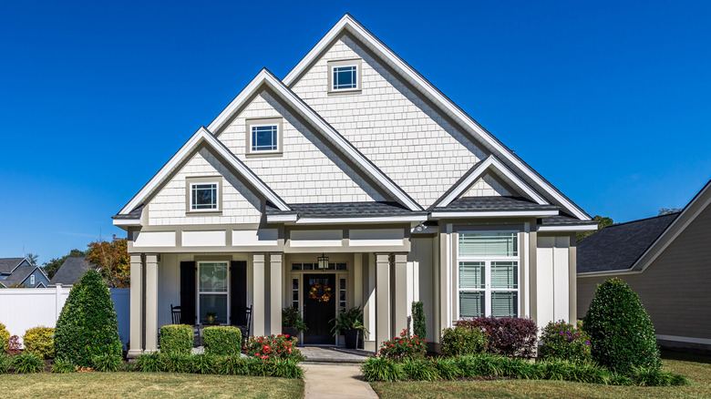 Craftsman house with light gray siding, medium gray trim, and a black front door