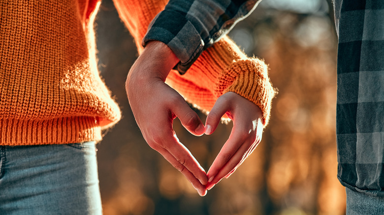 Couple forming heart with hands