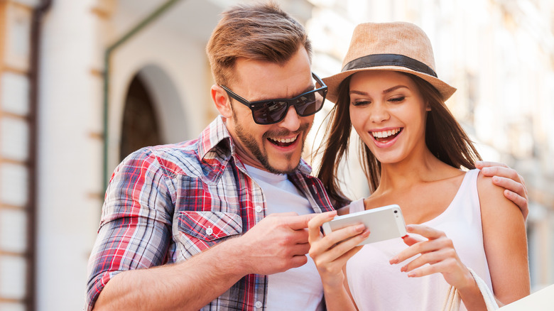 smiling couple looking at phone