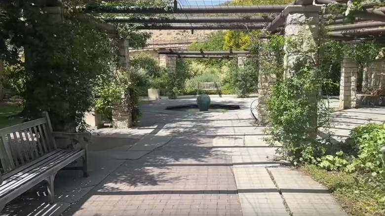 The English Garden at the Idaho Botanical Garden with benches, brick walkways, plants, and pergolas