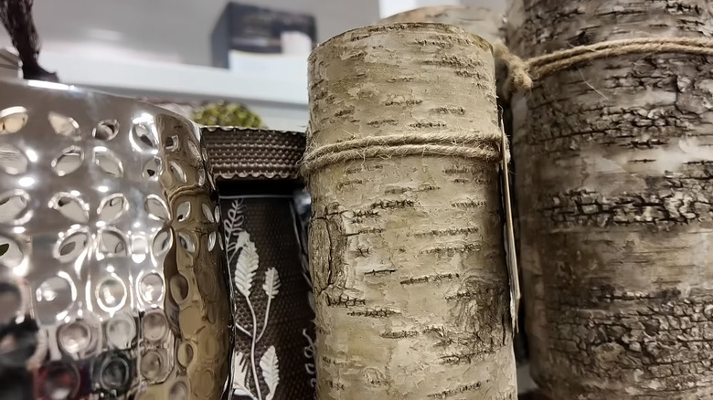 Two large birch pillar candles sit on a shelf at HomeGoods