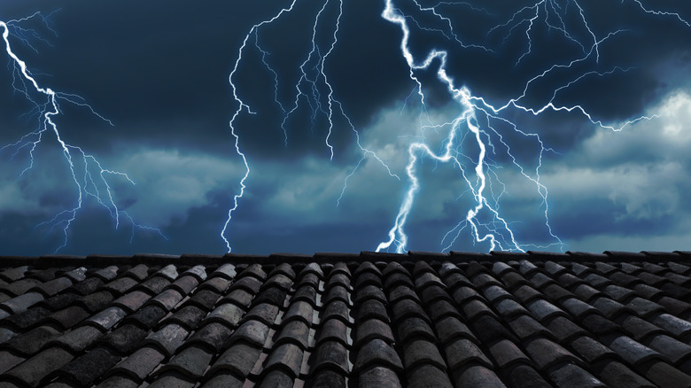 forked lightning behind tiled roof